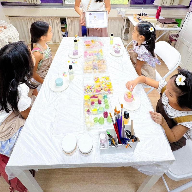 Children choosing decorations during a creative candle-making workshop
