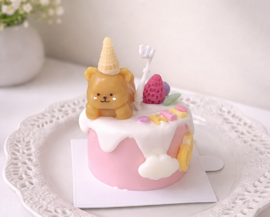 Pastel cake candle decorated with a bear and dessert pieces