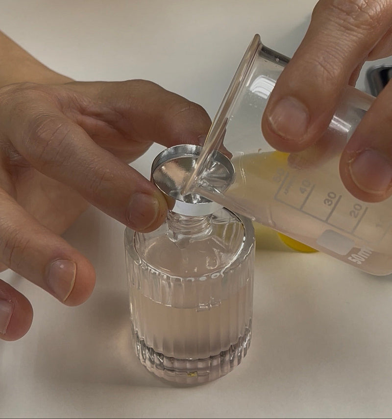 Pouring a finished fragrance into a personalised perfume bottle