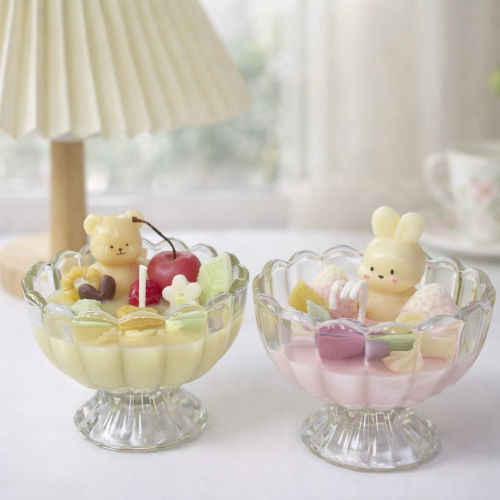 Two playful dessert candles decorated with a bear, bunny and colourful wax pieces