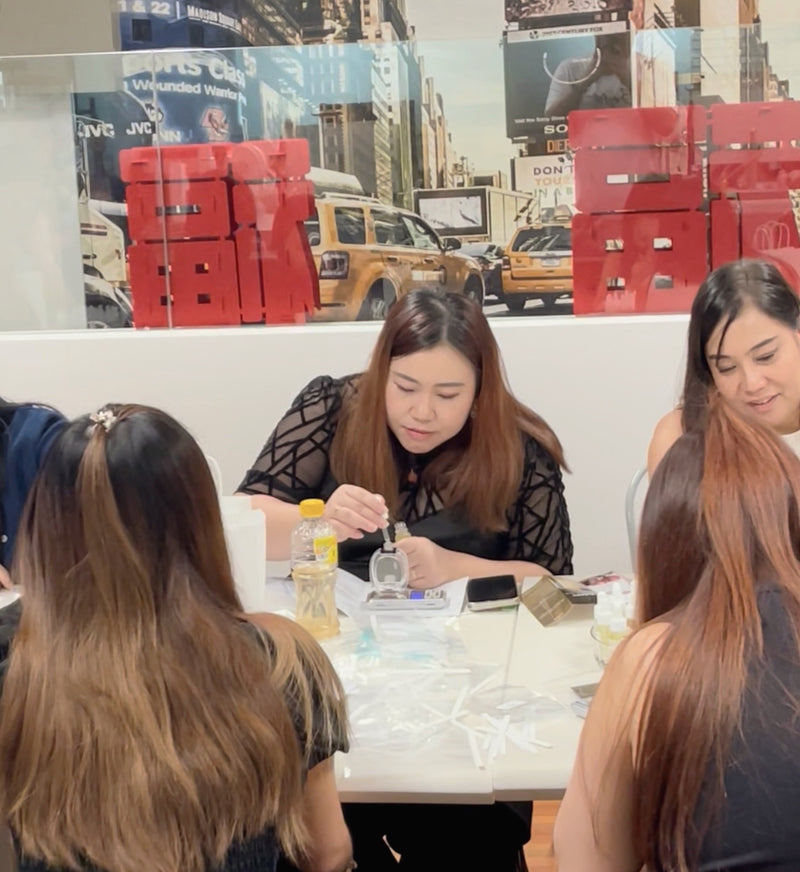 Guests blending their own scents around a workshop table