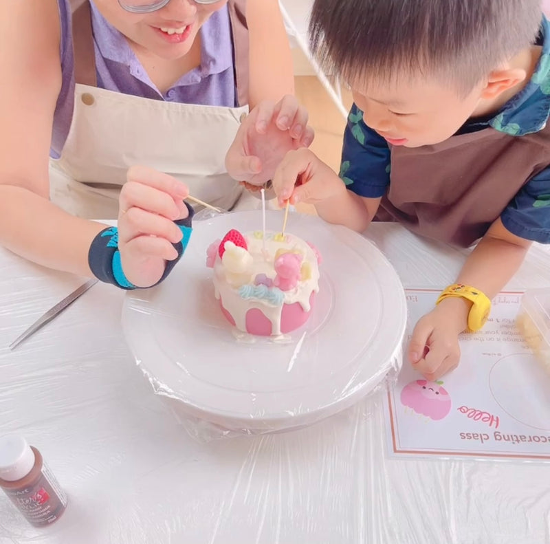 Mother and child adding the finishing touches to their cake candle together