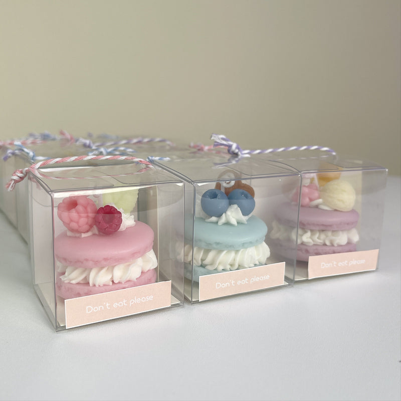 Three pastel macaron candles presented in clear gift boxes